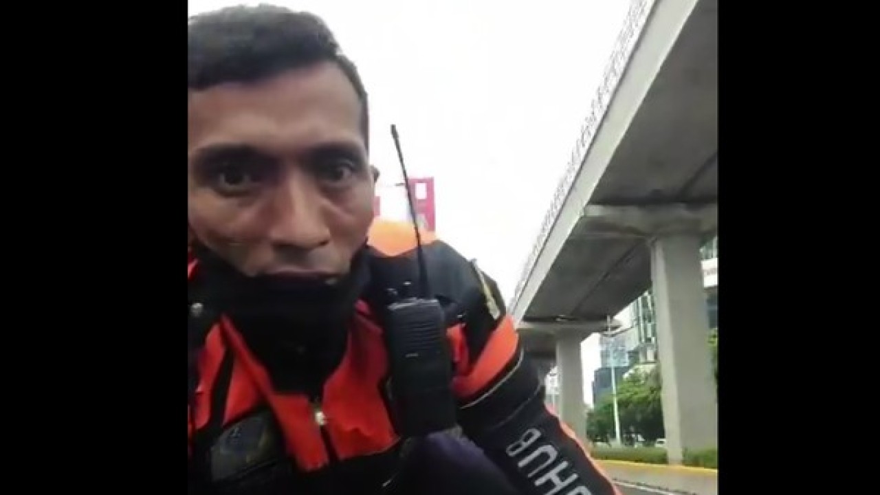 Petugas Dishub naik ke kap mesin mobil.