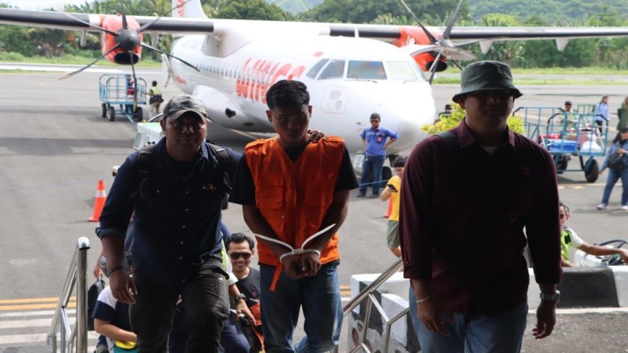 Polisi mengiring MD pelaku penganiaya OGDJ di bandara Ende usai ditangkap di Bali. ANTARA/Ho-Polres Ende