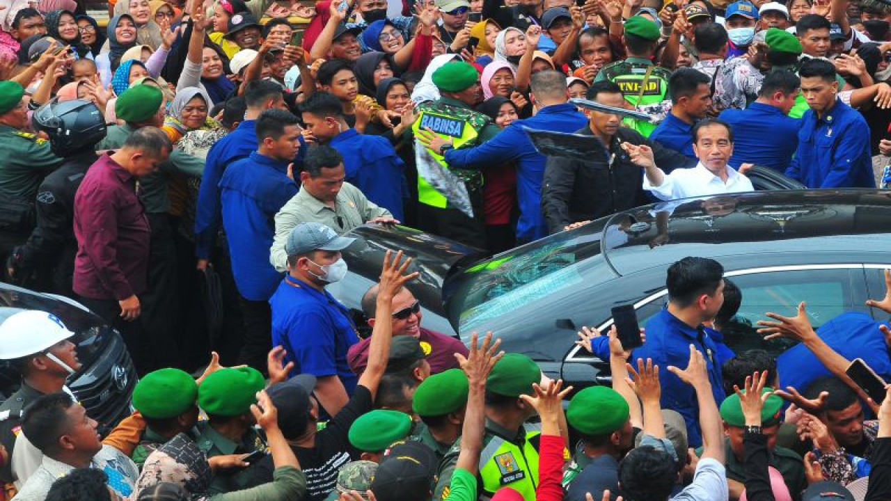 Presiden Joko Widodo saat membagikan kaos kepada warga setelah meresmikan jalan inpres di Ngawen, Kabupaten Blora, Jawa Tengah, Selasa (23/1/2024). (ANTARA FOTO/Yusuf Nugroho/aww)