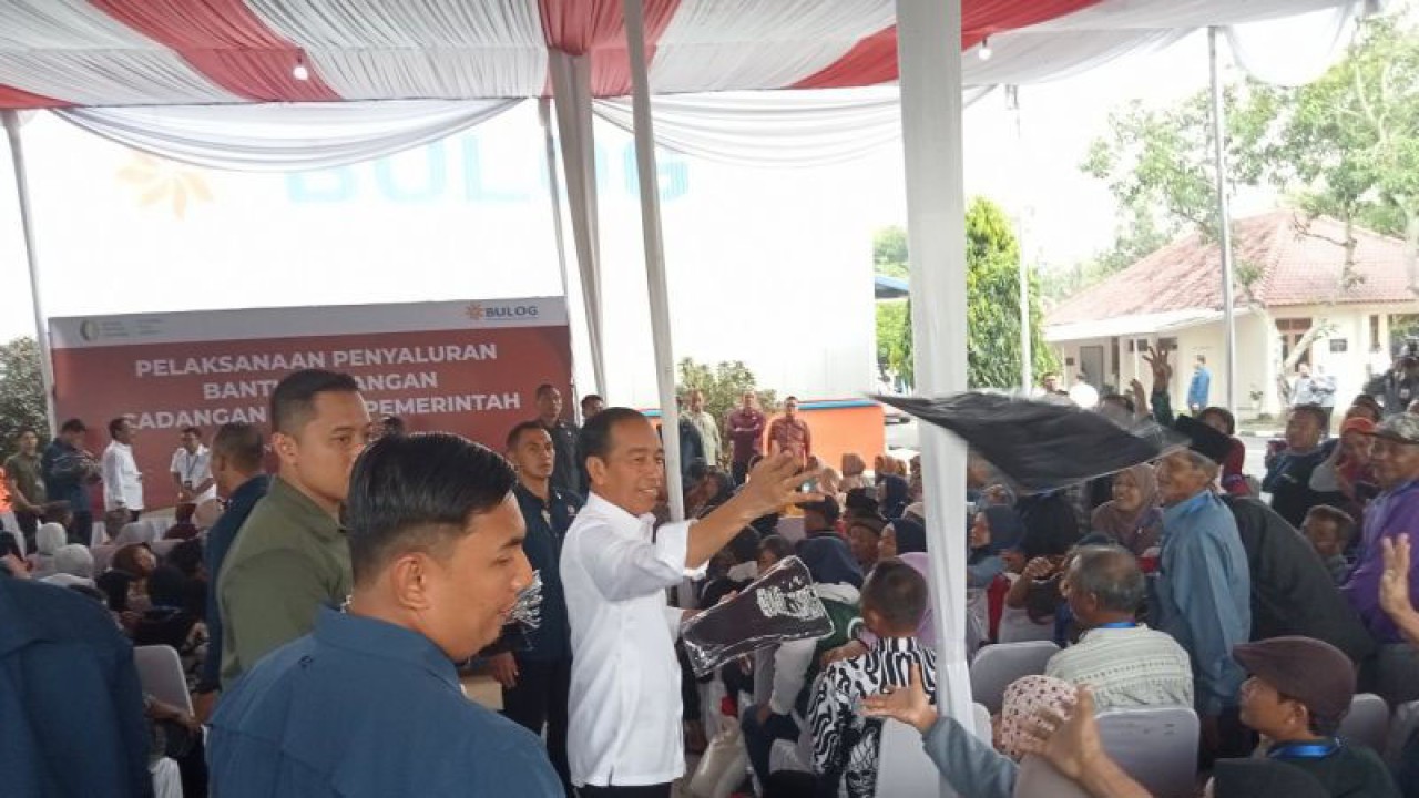 Presiden Jokowi membagi bagikan kaos kepada warga yang menerima bantuan pangan beras cadangan pemerintah di Gudang Bulog Pajangan, Kabupaten Bantul, Daerah Istimewa Yogyakarta. Selasa (30/1/2024) (ANTARA/Hery Sidik)