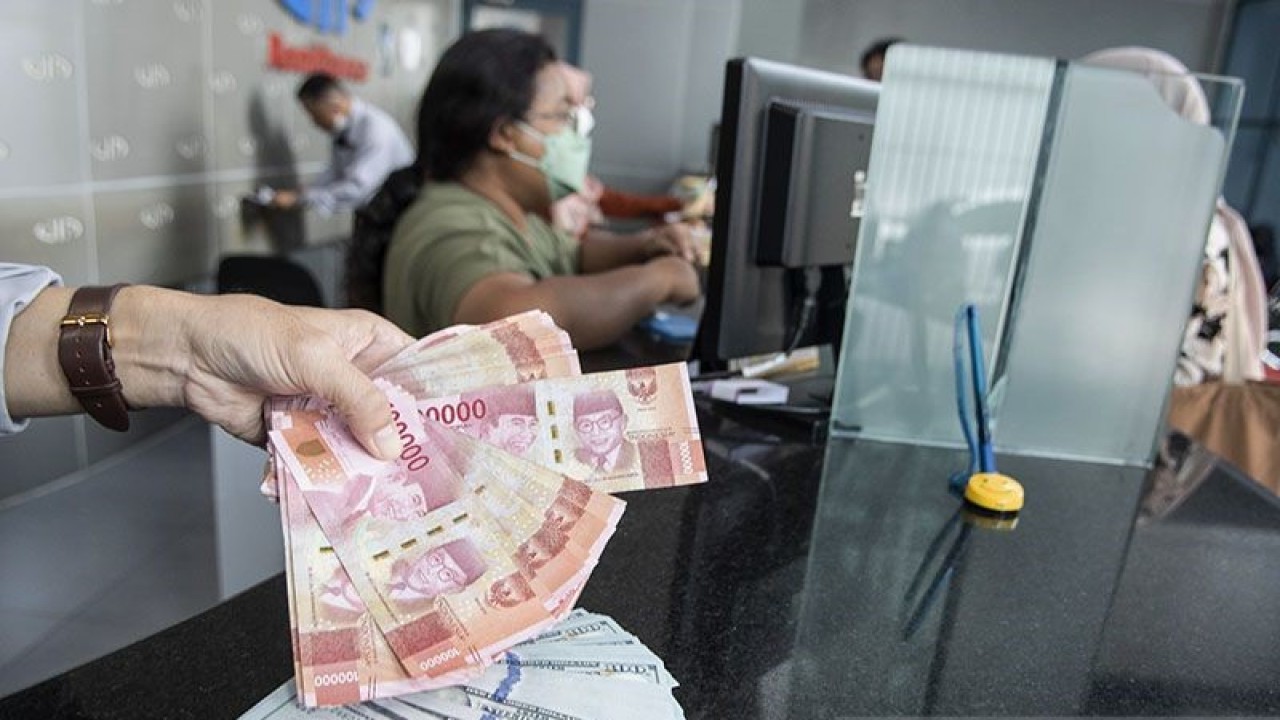 Ilustrasi - Petugas menunjukan uang pecahan rupiah dan dolar AS di gerai penukaran mata uang asing di Jakarta. ANTARA FOTO/Muhammad Adimaja/foc/aa.