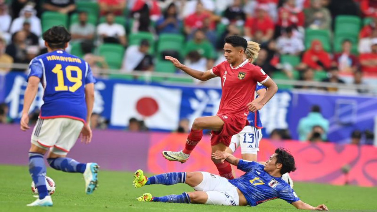 Pesepak bola Timnas Indonesia Marselino Ferdinan (tengah) menggiring bola dengan dihalangi pesepak bola Timnas Jepang Reo Hatate (kanan) dan Yuta Nakayama (kiri) pada laga penyisihan grup D Piala Asia 2023 di Stadion Al Thumama, Doha, Qatar, Rabu (24/1/2024). Indonesia dikalahkan Jepang dengan skor 1-3. ANTARA FOTO/Yusran Uccang/aww.