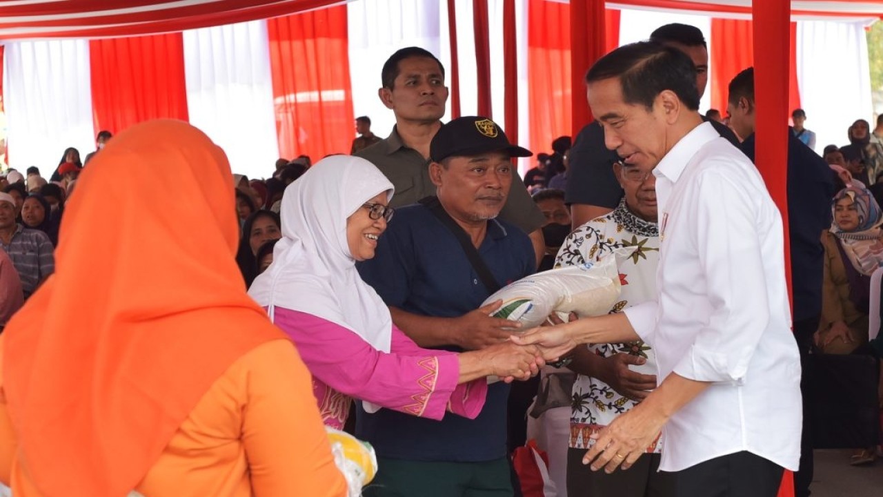 Presiden Jokowi saat menyerahkan bantuan beras.