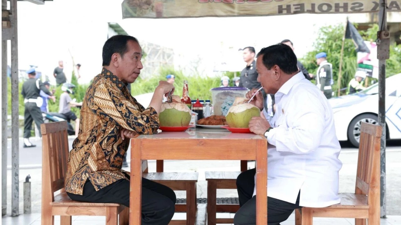 Presiden Jokowi dan Menteri Pertahanan Prabowo tengah makan bakso dan minum air kelapa.