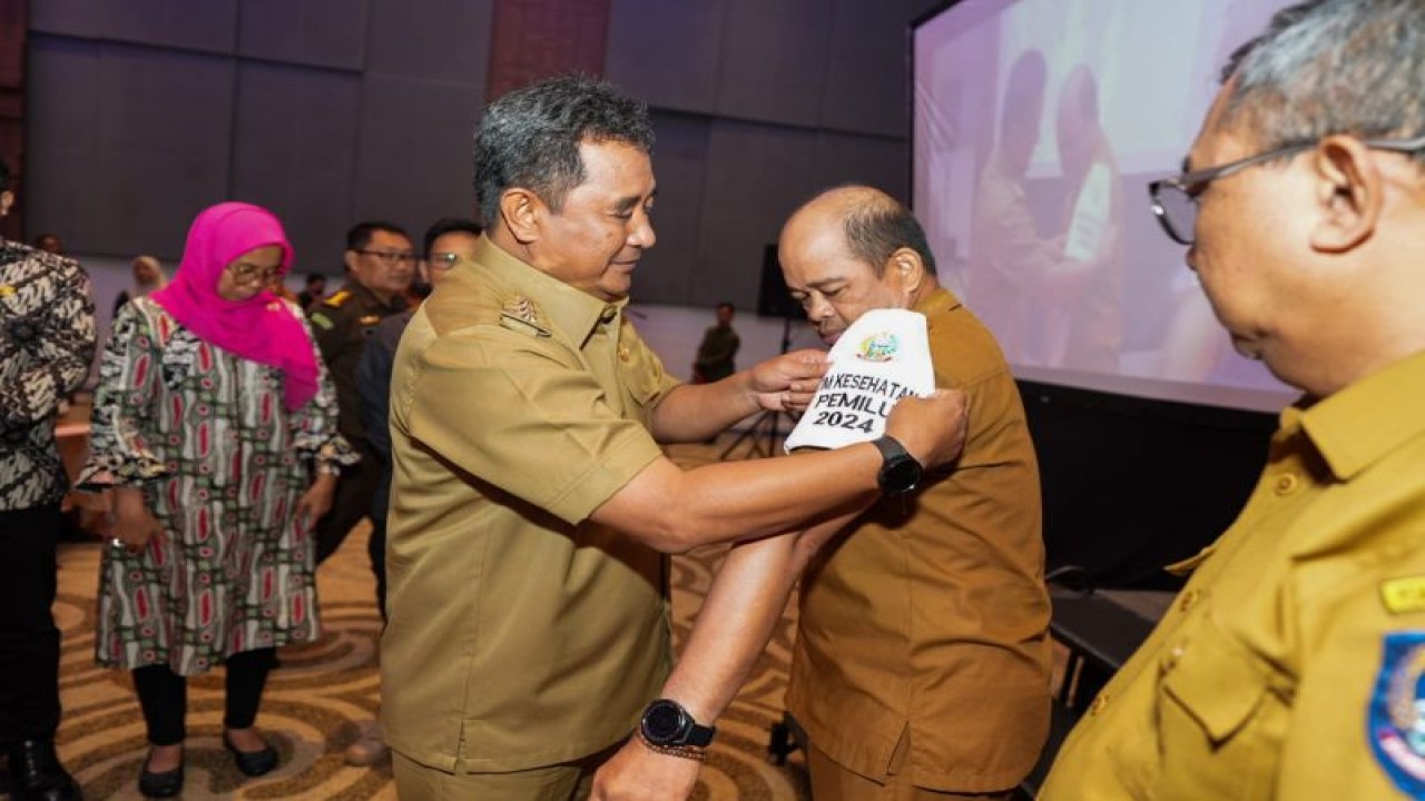 Pj Gubernur Sulsel Bahtiar Baharuddin, memasangkan ban lengan kepada tim Satgas Kesehatan di Makassar.ANTARA/HO-Humas Pemprov Sulsel