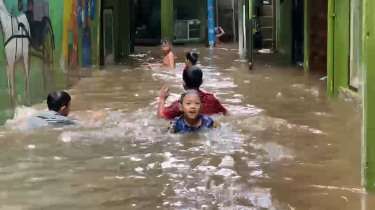 Anak-anak malah asyik berenang di banjir yang melanda Kebon Pala Jaktim/ist