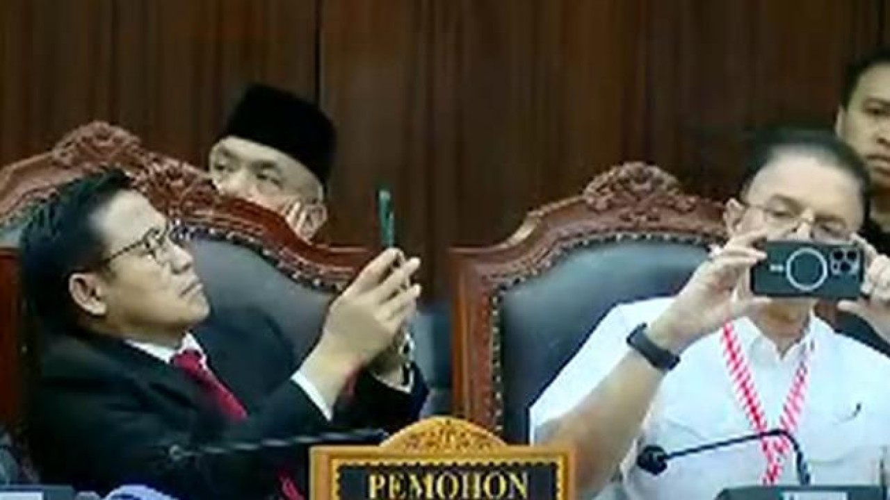 Cawapres nomor urut 1, Muhaimin Iskandar atau Cak Imin saat memainkan ponselnya ketika sidang sengketa hasil Pilpres 2024 di Mahkamah Konstitusi.