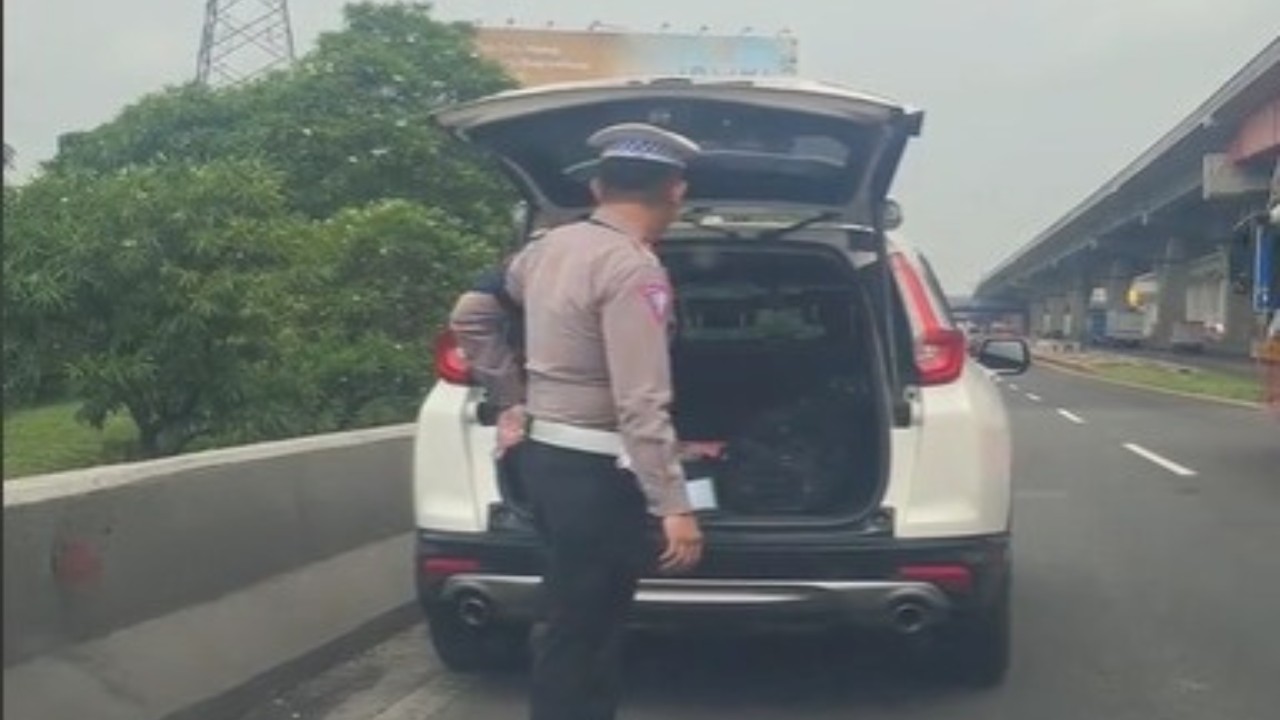 petugas Kanit mengecek mobil yang diduga meninggalkan mobilnya di pinggir jalan tol. (Tangkap layar)