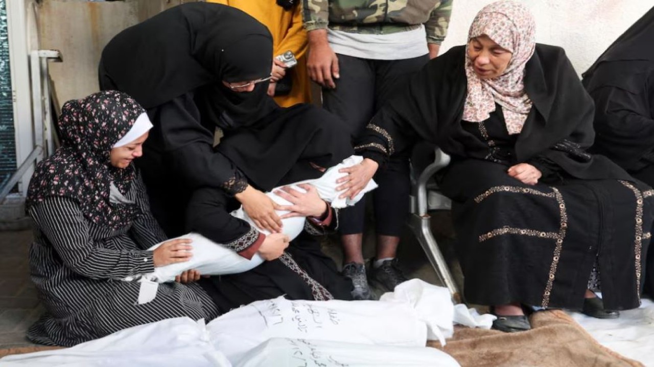 Keluarga berduka sambil memegang jenazah seorang warga Palestina yang tewas dalam serangan Israel terhadap rumah-rumah, di rumah sakit Abu Yousef al-Najjar di Rafah di selatan Jalur Gaza, 7 Desember 2023. (Foto: Ibraheem/Reuters)