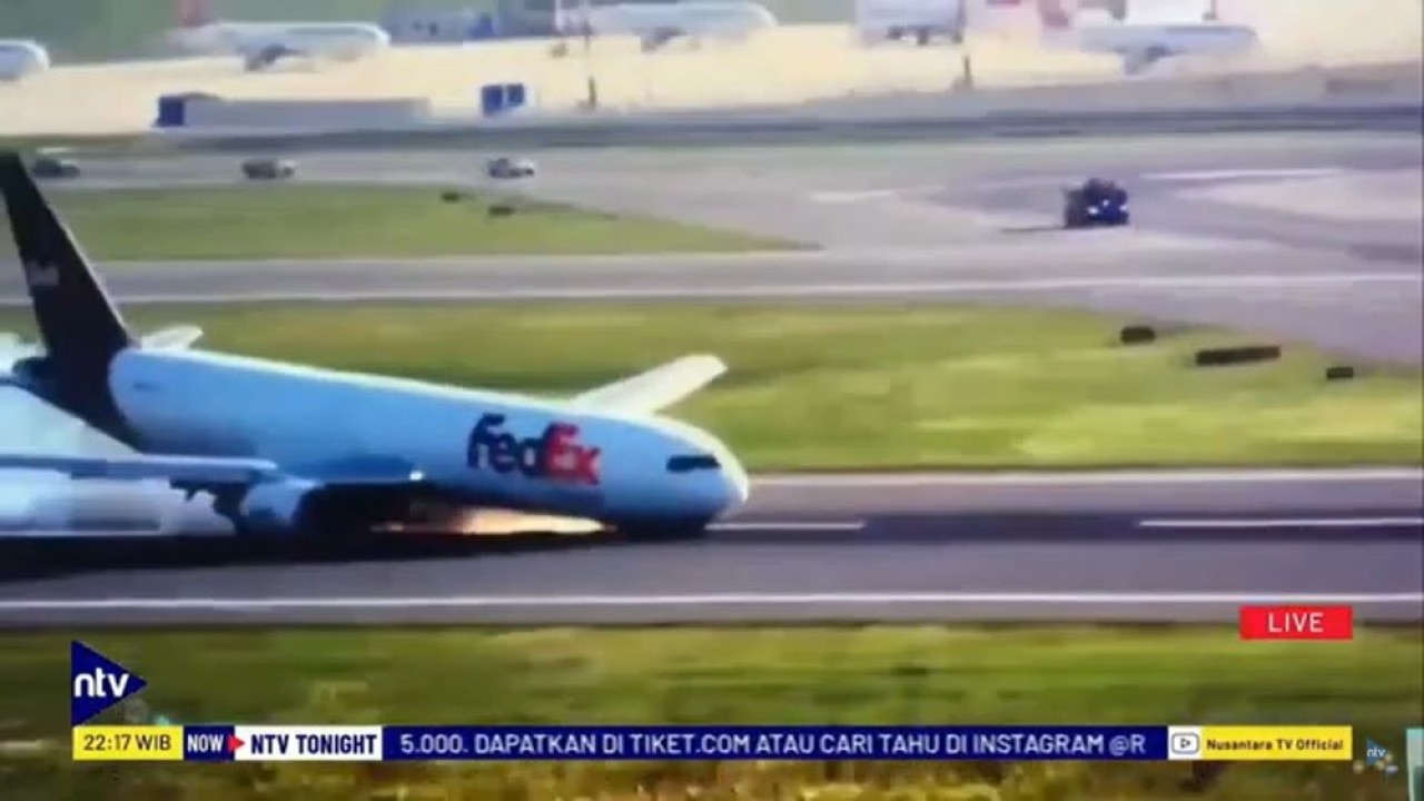 Percikkan api dan asap mengepul saat badan pesawat kargo FedEx bergesekkan dengan permukaan landasan