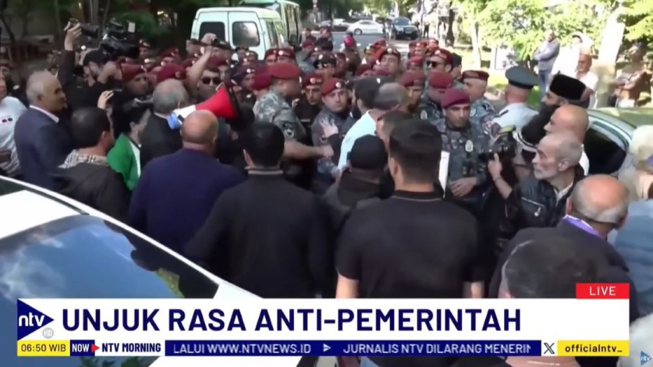 Aparat keamanan menahan seorang pengunjuk rasa saat menuntut pengunduran diri Perdana Menteri Armenia Nikol Pashinyan.