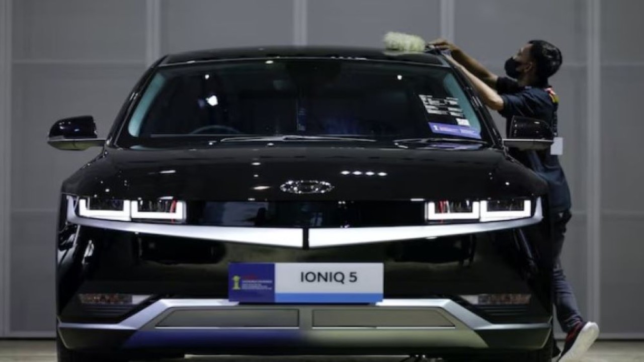Seorang pekerja membersihkan mobil listrik Hyundai IONIQ 5 selama pameran Indonesia International Motor Show (IIMS) di Jakarta, Indonesia, 16 Februari 2023. (Foto: REUTERS/Willy Kurniawan)