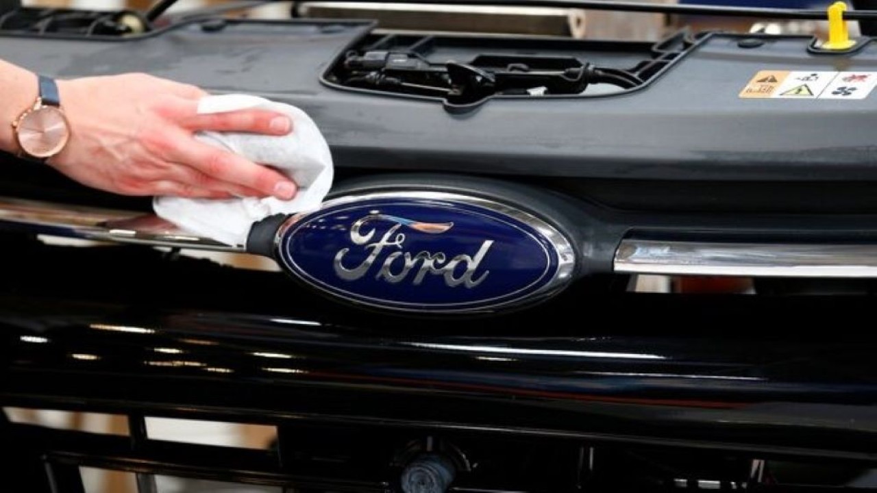 Seorang pekerja membersihkan bagian depan mobil Ford menjelang Munich Motor Show IAA Mobility 2021 di Munich, Jerman, 6 September 2021. (Foto: REUTERS/Michaela Rehle)