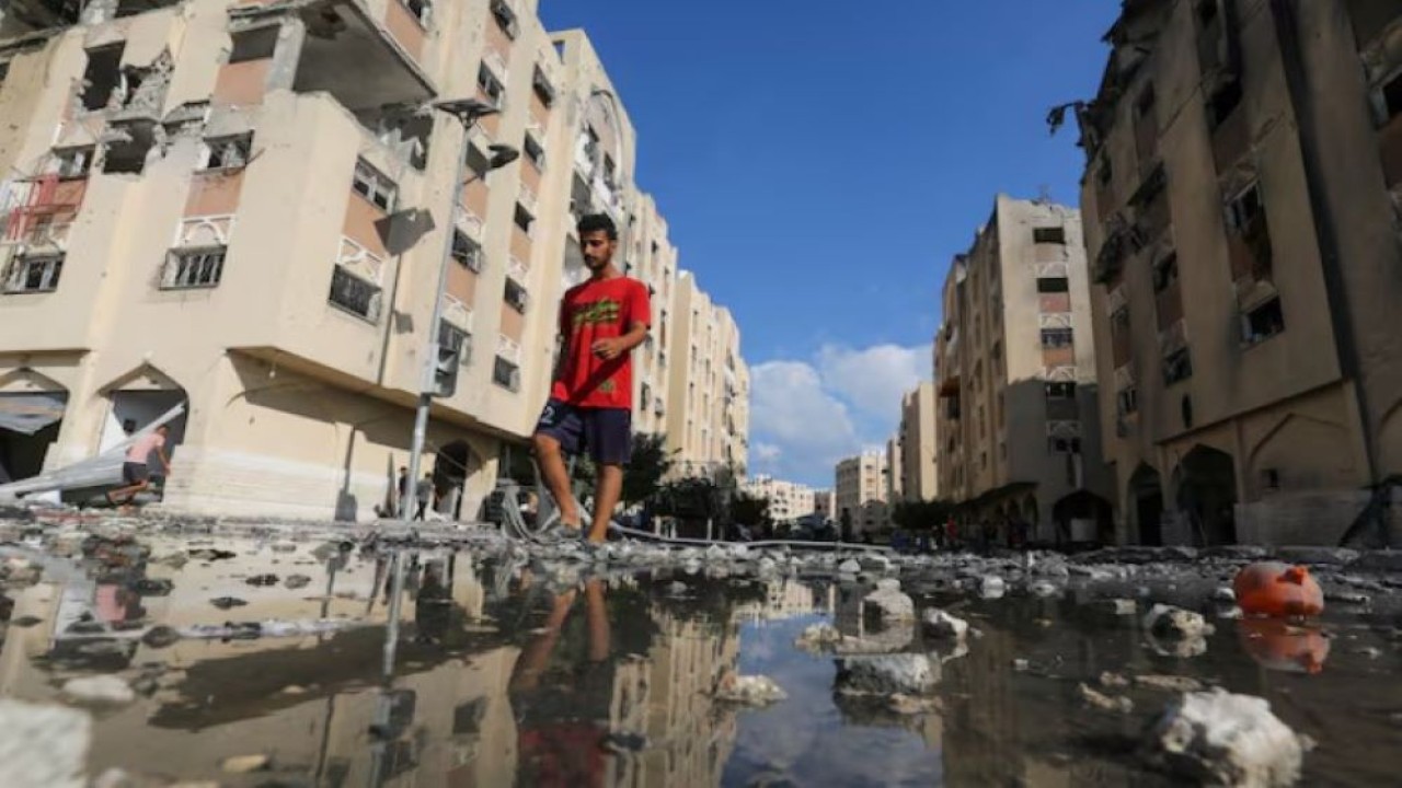 Seorang pria Palestina berjalan melewati bangunan tempat tinggal yang terkena serangan Israel di Kota Hamad, di tengah konflik Israel-Hamas, di Khan Younis di Jalur Gaza selatan, 11 Agustus 2024. (Foto: Dok/Hatem Khaled/REUTERS)