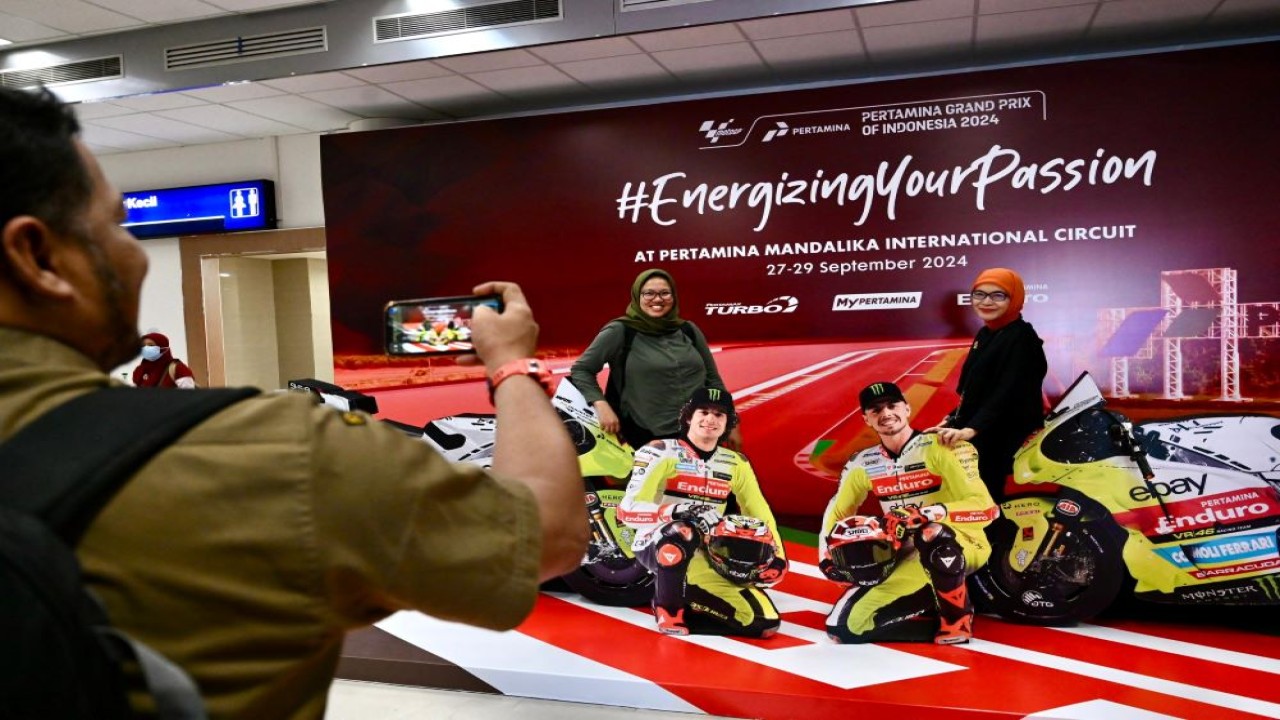 Antusias wisatawan saat berfoto di spot foto unik dengan papan menyerupai pembalap Tim VR46 MotoGP yang ada di Bandara Internasional Lombok. Selasa (24/9/2024)/Foto: Istimewa