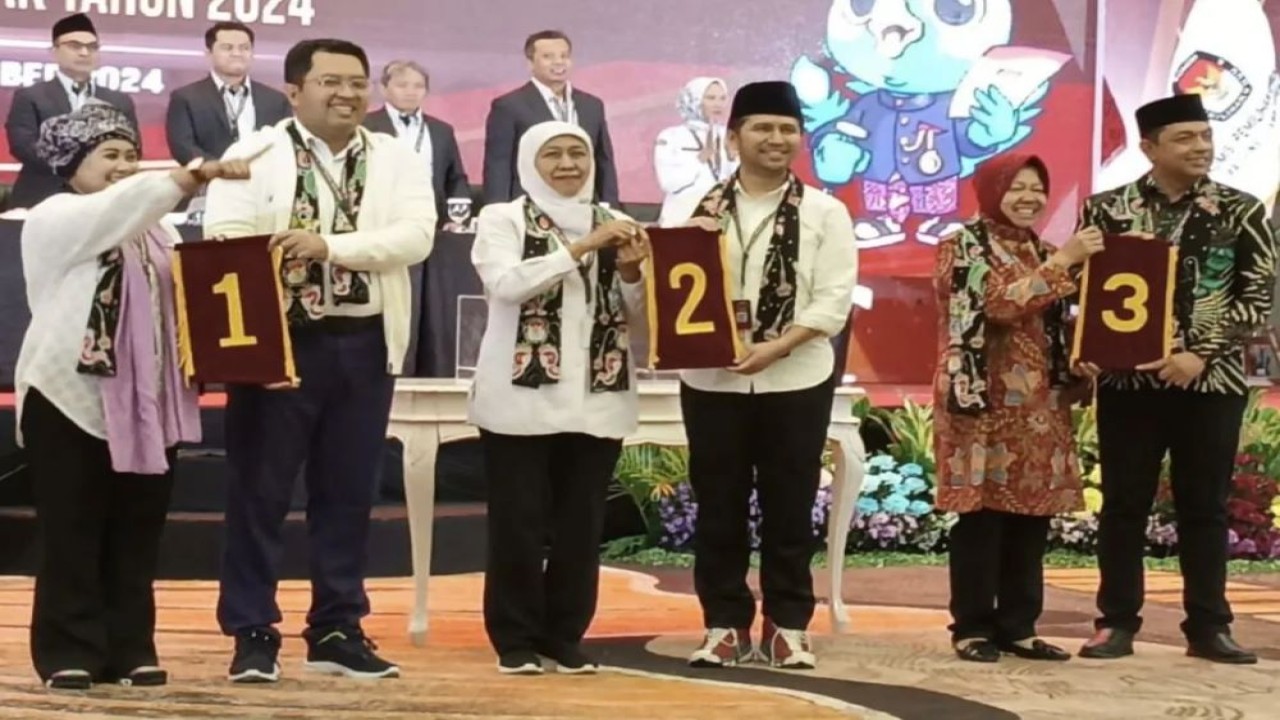 Tiga pasangan calon menunjukkan nomor urut saat rapat pleno terbuka pengundian dan penetapan nomor urut pasangan calon gubernur dan wakil gubernur, di Surabaya, Jawa Timur, Senin (23/9/2024). ANTARA/Faizal Falakki