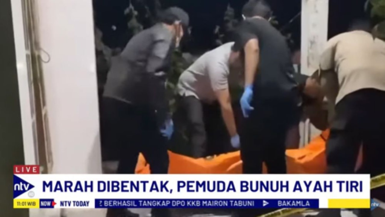 Personel kepolisian mengevaluasi korban yang tewas dibunuh anak tirinya