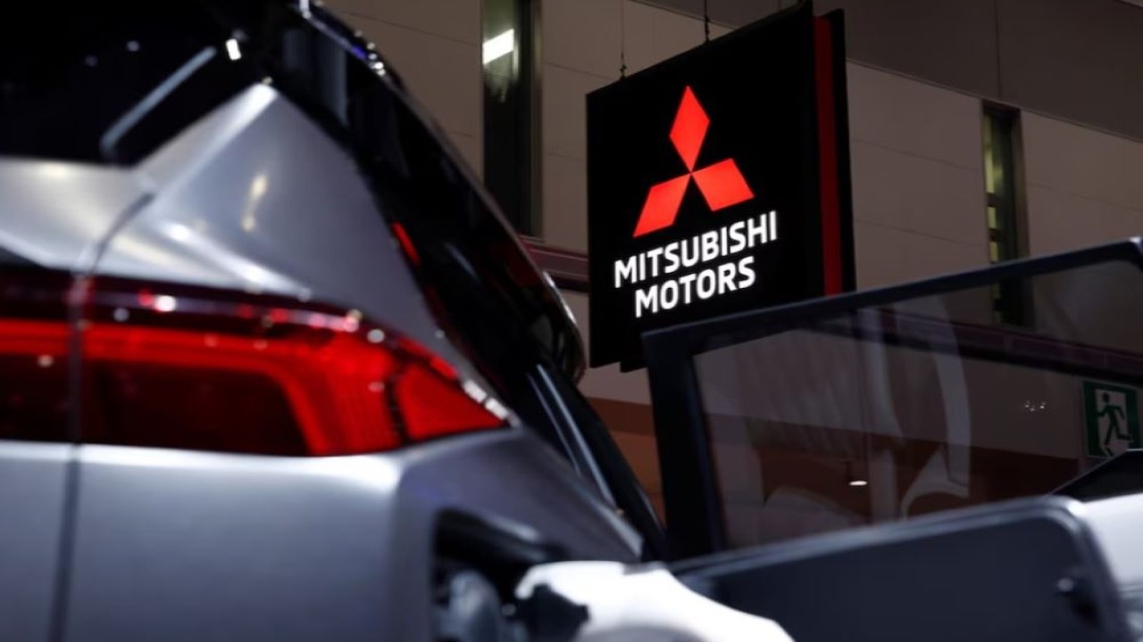 Papan nama Mitsubishi Motors terpampang di sebelah mobil listrik Mitsubishi Motors di Tokyo Motor Show, di Tokyo, Jepang, 24 Oktober 2019. (Foto: Dok/Edgar Su/Reuters)