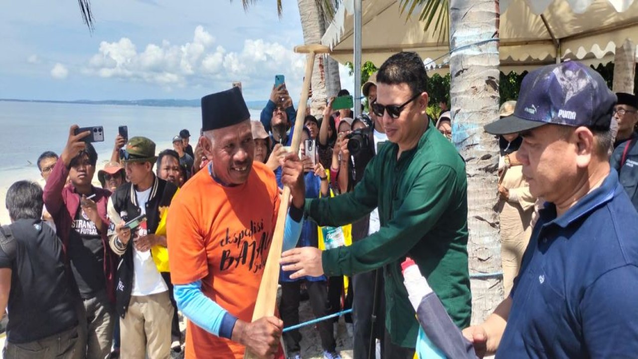 Mohamad Atqa, Ketua Tim Kerja Diplomasi Budaya Kementerian Kebudayaan RI secara simbolis menyerahkan dayung Ketua tim ekspedisi, Ridwan Alimuddin menandai dimulainya pelayaran Ekspedisi Bajau Sulawesi/Foto: Istimewa