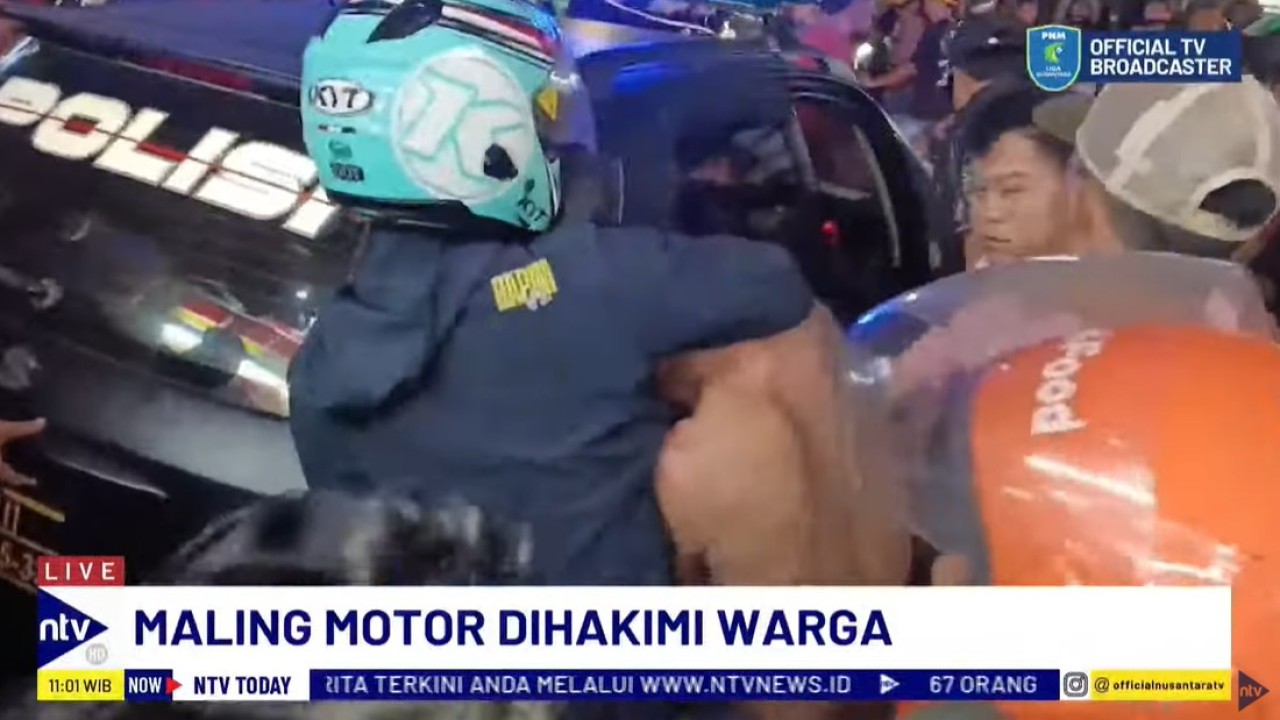 Pelaku curanmor yang babak belur diamankan dan digiring masuk ke dalam mobil patroli polisi.