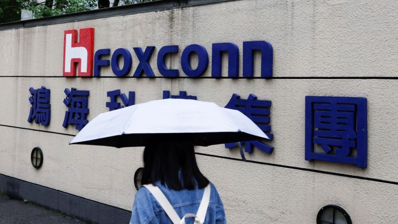 Seorang wanita berjalan melewati logo Foxconn di luar gedung perusahaan di Taipei, Taiwan, 31 Oktober 2022. (Foto: Dok/Carlos Garcia Rawlins/Reuters)