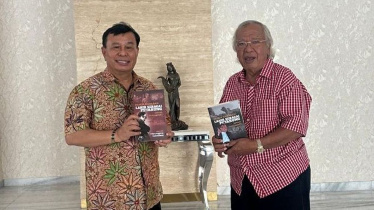 Panda Nababan memberikan buku otobiografinya berjudul 'Panda Nababan: Lahir sebagai Petarung, sebuah Otobiografi' kepada Nurdin Tampubolon.