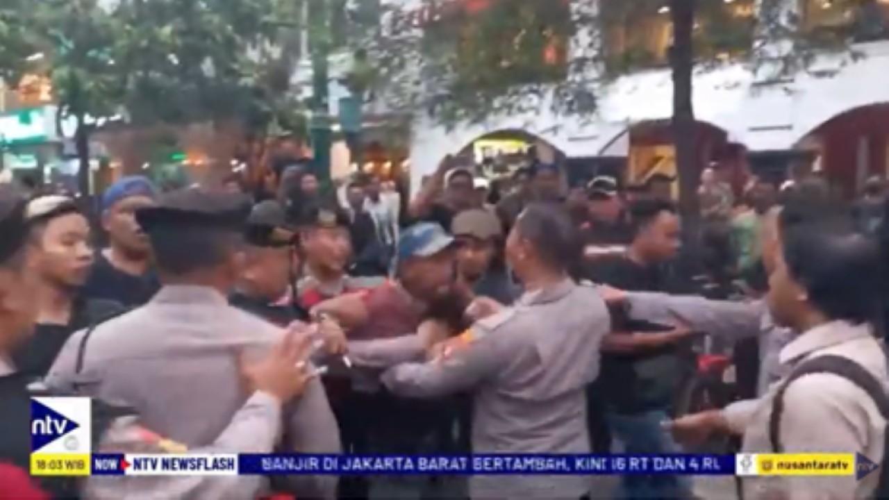 Personel kepolisian berupaya menertibkan massa PKL Malioboro