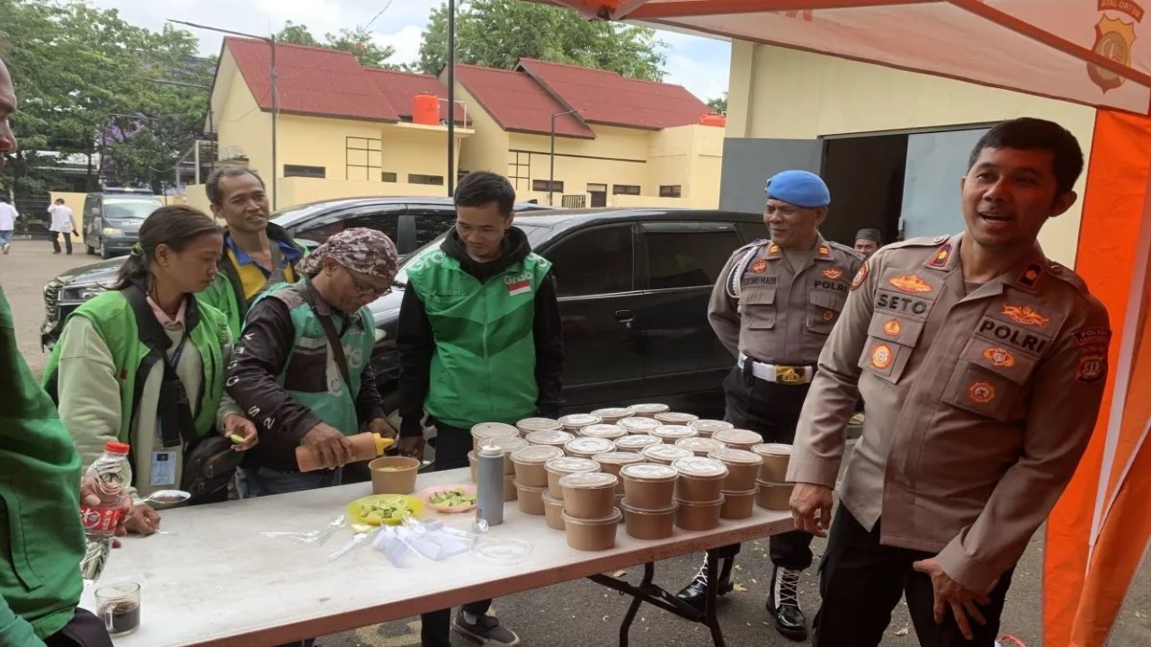 Kapolsek Kepala Gading Kompol Seto Handoko Putra tengah berbincang-bincang dengan pengemudi ojek daring di wilayah Kelapa Gading saat kegiatan makan bareng di Mako Polsek Kelapa Gading. (Foto: ANTARA/Mario Sofia Nasution)