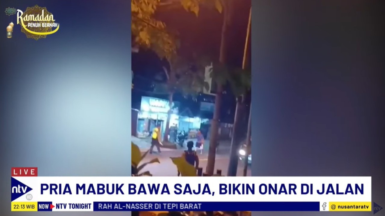 Pria mabuk tampak sedang mengamuk sambil membawa golok dan mengancungkan sajam ke arah polisi.