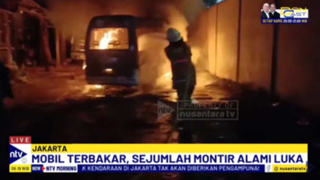 Petugas pemadam kebakaran berupaya memadamkan api yang membakar sebuah mobil yang sedang diperbaiki di bengkel