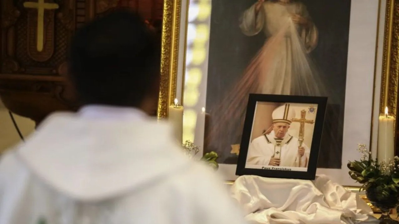 Umat Katolik berdoa di depan foto Paus Fransiskus saat mengikuti Misa Requiem di Gereja Katolik Santo Willibrordus,Ternate, Maluku Utara, Sabtu (26/4/2025). (Foto: ANTARA FOTO/Andri Saputra/nz)