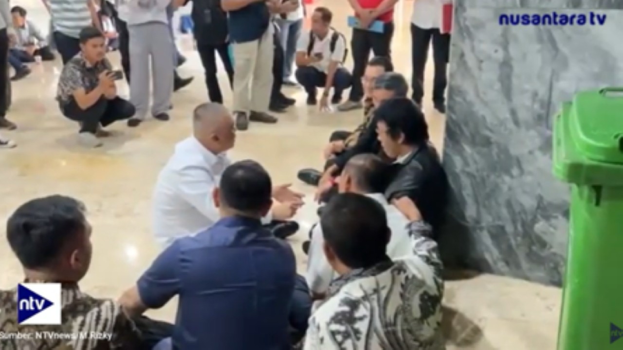 Anggota Komisi V DPR RI Adian Napitupulu lesehan bareng Menhub Dudy Purwagandhi membahas nasib ojol di depan ruang rapat DPR