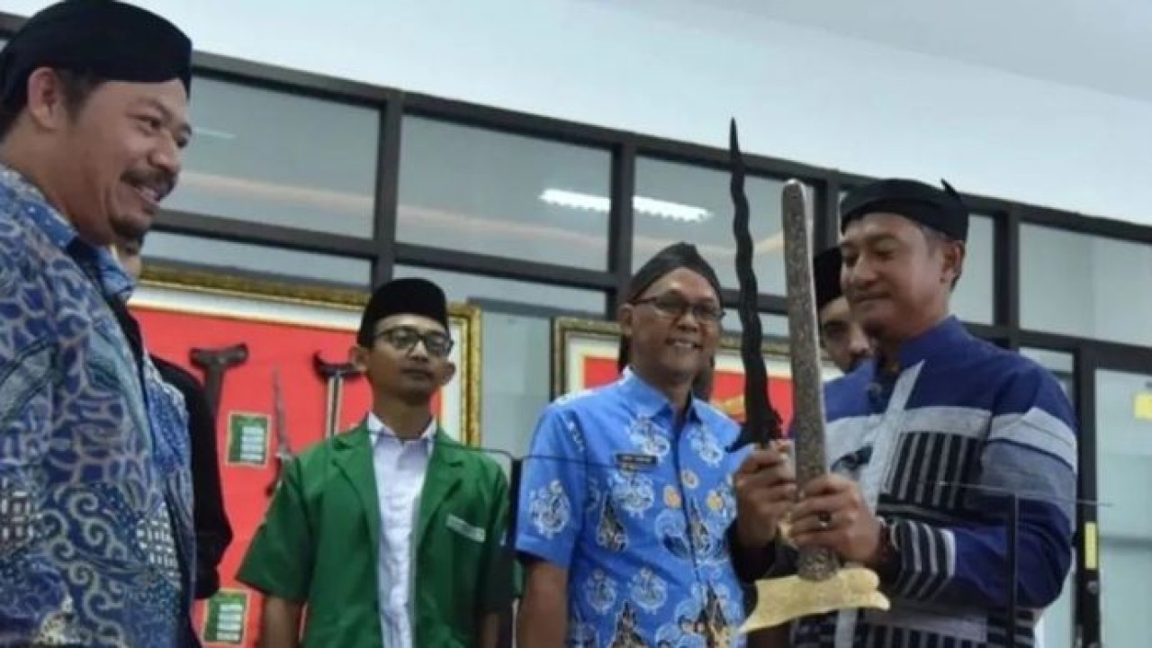 Bupati Pacitan Indrata Nur Bayuaji menyerahkan keris kepada Staf Khusus Menteri Kebudayaan RI Bidang Sejarah dan Perlindungan Warisan Budaya Basuki Teguh Yuwono saat pembukaan Gelar Budaya Luwung di Gedung Perpustakaan Daerah Pacitan, Jawa Timur. (Antara)