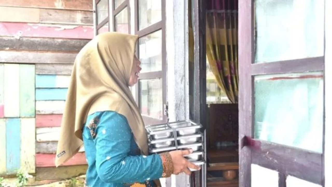 Seorang tim pendamping keluarga (TPK) sedang mengantarkan Makan Bergizi Gratis (MBG) untuk sasaran ibu hamil, ibu menyusui, dan balita ke rumah penerima manfaat. ANTARA/HO-Kemendukbangga/BKKBN. (Antara)