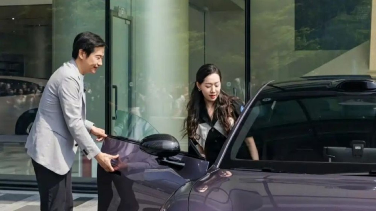 CEO Xiaomi Lei Jun menggunakan gagang pintu mekanis baru untuk membuka Xiaomi SU7 bagi pemilik barunya. (Foto: Istimewa via CarNewsChina)