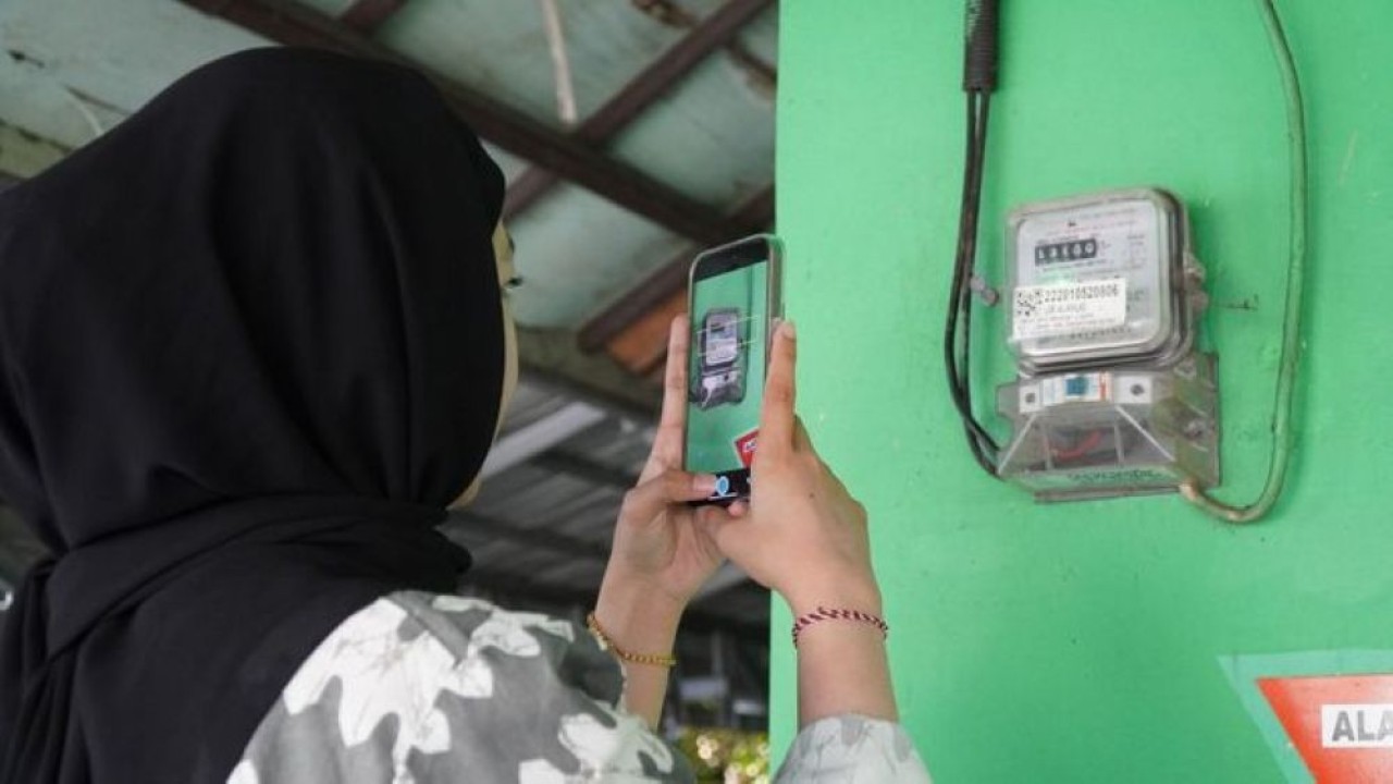 Ilustrasi pelanggan tengah memanfaatkan fitur SwaCAM di aplikasi PLN Mobile untuk mencatat stand meter listrik. (Foto: Istimewa)